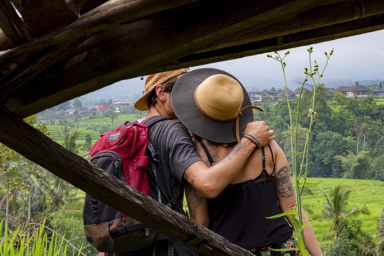 Vue depuis un abris de bois d'un couple s'enlaçant devant des champs de riz, Indonésie
