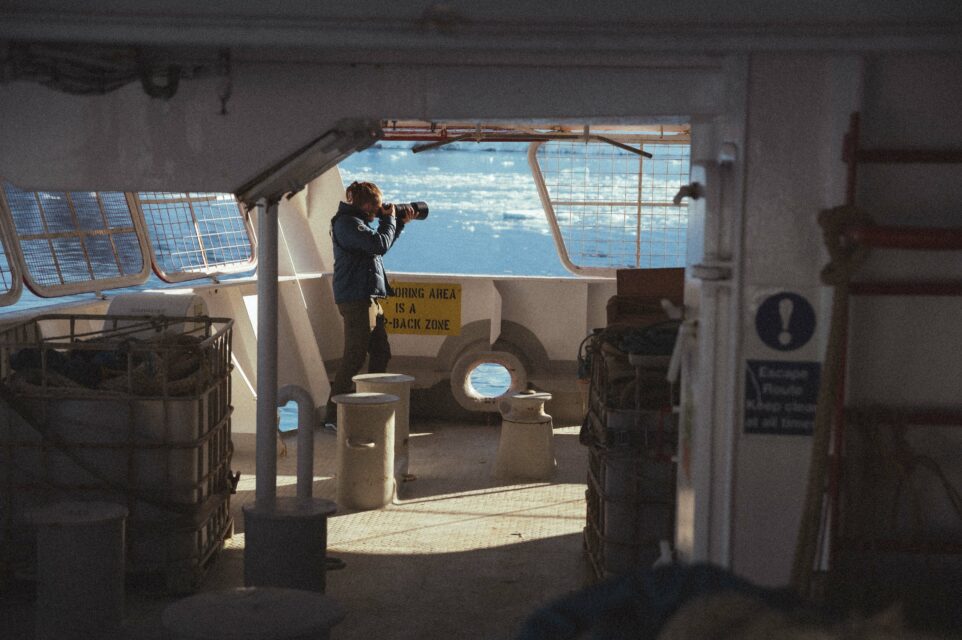 Mathys, photographe à l'arrière d'un bateau face à l'océan